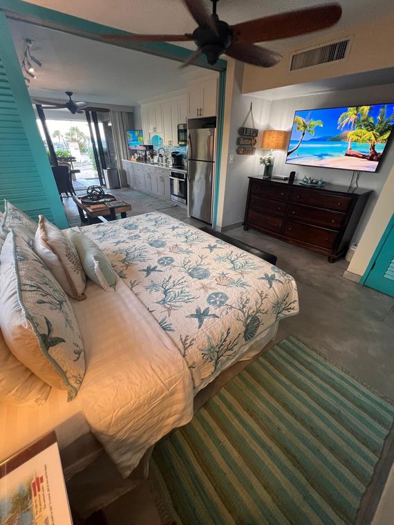 King bed, flat-screen TV and dresser in Unit D101, a Sapphire Beach Resort condo rental