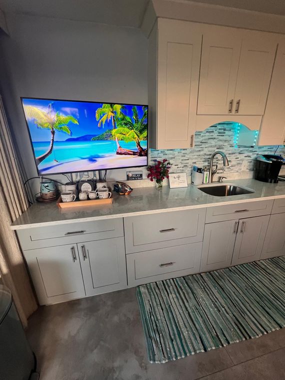 Kitchen counter with coffee station and a second flat-screen TV in this St. Thomas rental for two couples